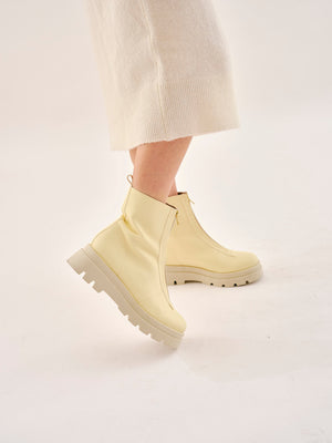 Bogota cream vegan boots for women worn on foot in motion highlighting fit, flexibility and chunky sole