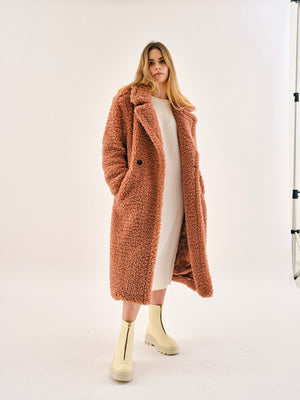 Woman wearing Bogota cream vegan boots styled with long coat and neutral outfit, sustainable winter fashion