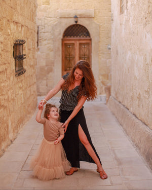 Woman wearing Cabo vegan lace up sandals with child walking together in Mediterranean street setting