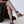 Close up of woman wearing Camila Plus vegan lace up heels with black ribbons styled with black dress while seated