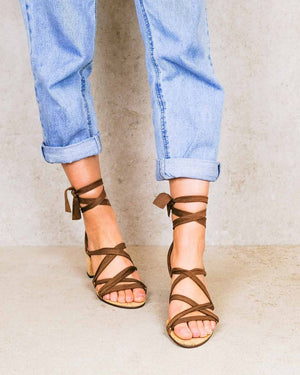 Close up of woman wearing Camila Plus vegan lace up heels with brown ribbons styled with rolled up jeans