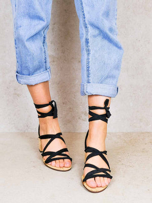 Front view of woman wearing Camila vegan lace up heels with black ribbons styled with rolled up jeans