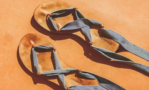 Vegan summer sandals with interchangeable blue ribbons on a terracotta background